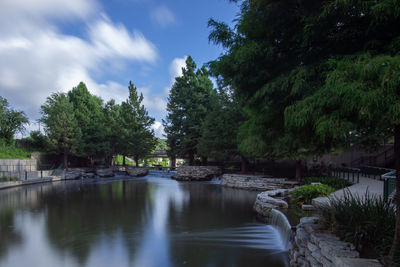 Scenic view of river amidst trees against sky