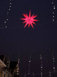 Low angle view of illuminated ferris wheel against sky at night