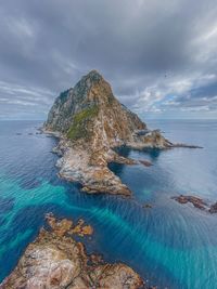 Rock formation in sea against sky