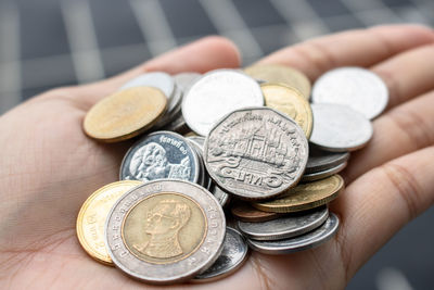 Close-up of hand holding coins