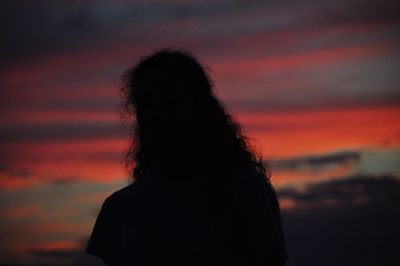 Silhouette woman against sky during sunset