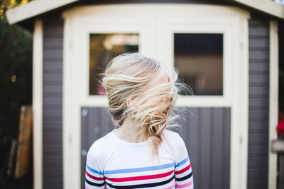 Rear view of woman in front of house