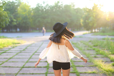 Rear view of woman standing on footpath