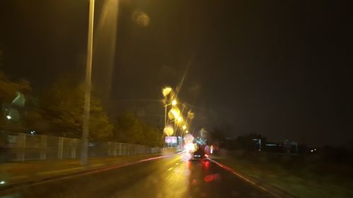 Cars on illuminated street at night