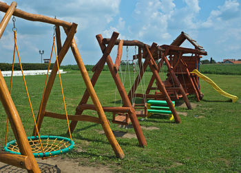 Empty chairs on field against sky