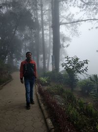Full length of young man standing in forest
