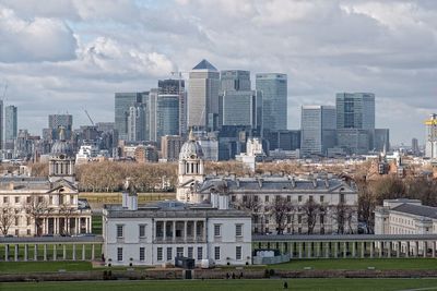 Buildings in city against cloudy sky