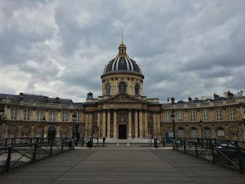 Exterior of institut de france against cloudy sky in city