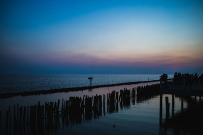 Silhouette pier on sea against sky at sunset