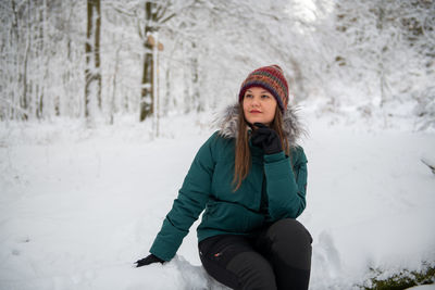 Young woman standing on snow covered field