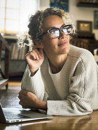 Portrait of young woman sitting at table