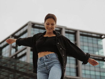 Portrait of smiling young woman standing against railing