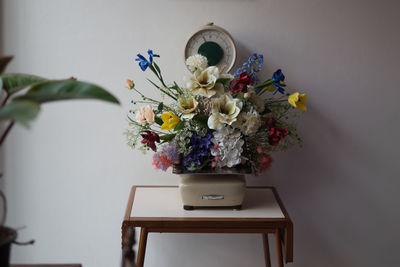 Flower vase on table against wall
