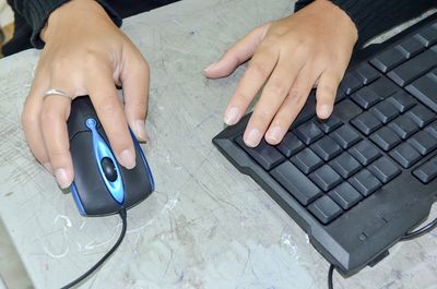 Cropped hands of woman using computer on table