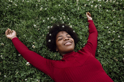 Portrait of smiling young woman lying on grass