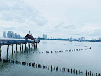 Pier on river against buildings in city