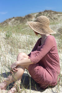 Midsection of woman sitting on field