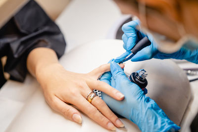 Midsection of woman working in nail studio