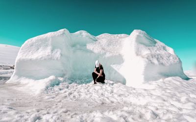 Full length of man standing on snow against clear sky