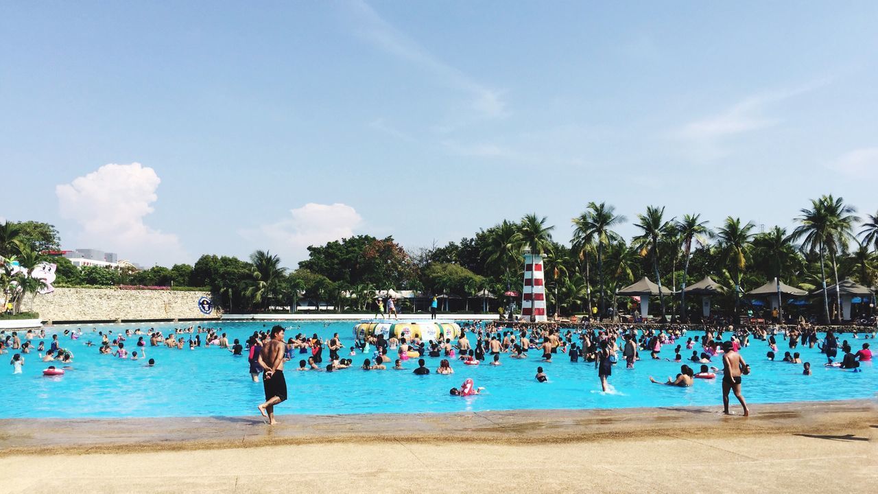 PEOPLE SWIMMING IN POOL AT BEACH