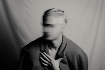 Blurred motion of man against curtain