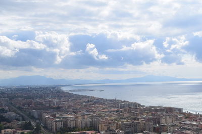 High angle view of buildings and sea against sky