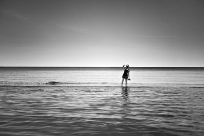 Man standing in sea against sky