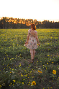 Rear view of woman standing on field