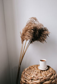 Close-up of coffee cup on table against wall at home