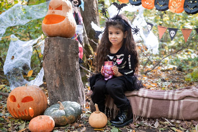 Halloween. cute arab girl in witch costume with pumpkin outdoor, having fun, celebrating halloween