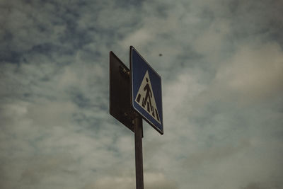 Low angle view of road sign against sky