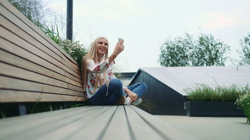 Woman sitting on chair against the sky