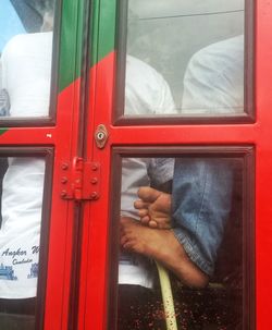 Close-up of hand on red door