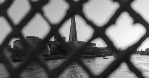 View of cityscape seen through chainlink fence