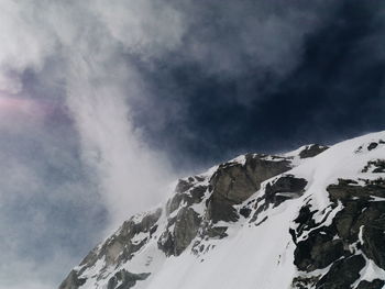 Scenic view of snow covered mountain against cloudy sky