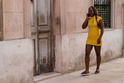 Full length of woman standing on footpath