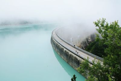 High angle view of dam by river during foggy weather