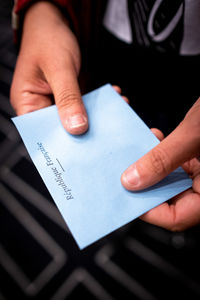 Midsection of man holding paper