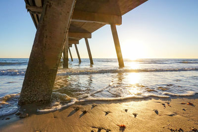 Pier over sea at glenelg beach during sunset