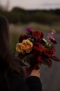 Low angle view of woman holding bouquet of flowering plant