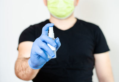 Midsection of man holding hands against wall