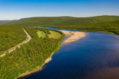 Aerial view of river karasjohka, sandy beach and coastal road at the border of finland and norway