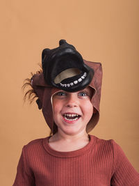 Portrait of smiling man wearing hat against wall