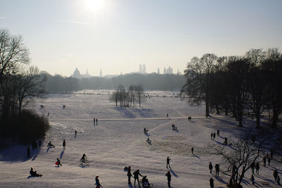 Group of people on snow covered land against sky