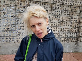 Portrait of woman standing against wall