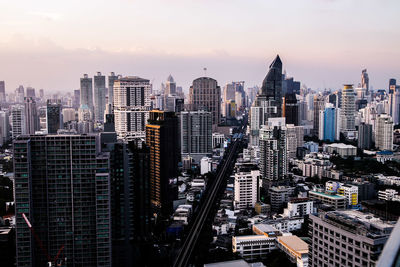 Aerial view of modern buildings in city against sky during sunset