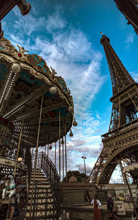 Low angle view of ferris wheel against cloudy sky