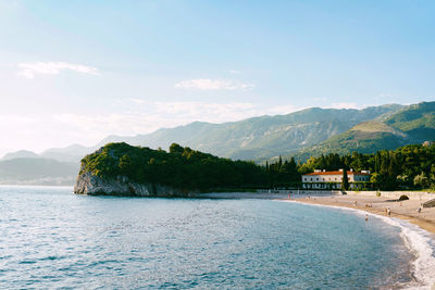 Scenic view of sea and mountains against sky