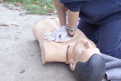 Midsection of paramedic performing cpr on mannequin