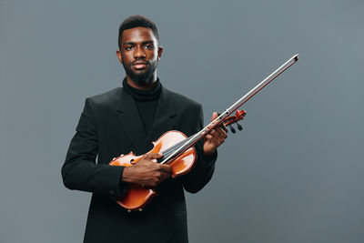 Man holding violin against white background